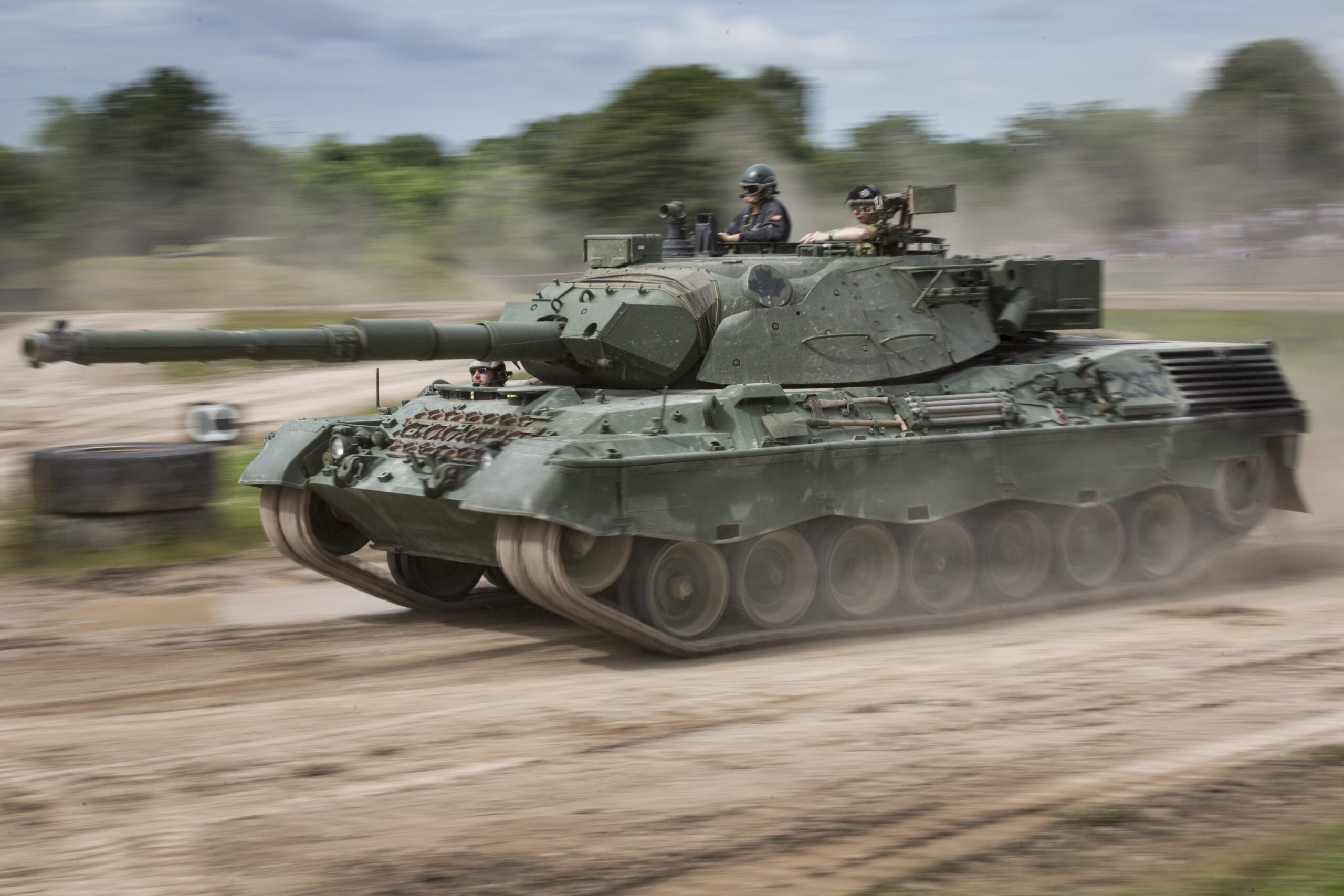 Leopard 1 Leopard 1 driving in the arena with 2 crew riding on the top of the tank
