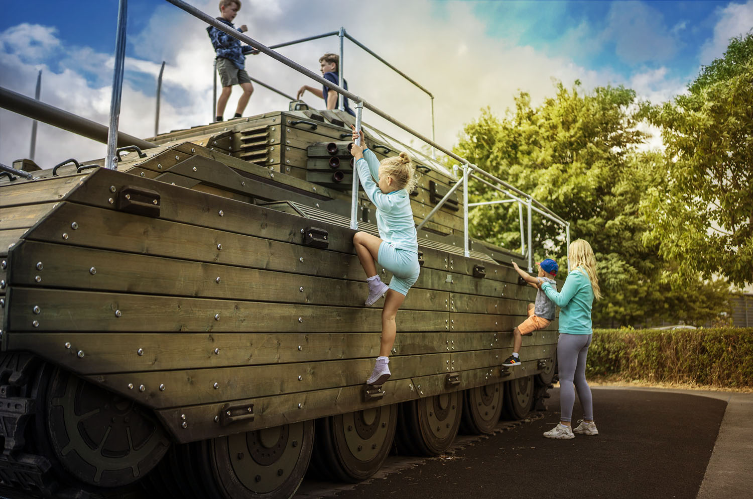 children on a wooden outdoor play area shaped like a tank