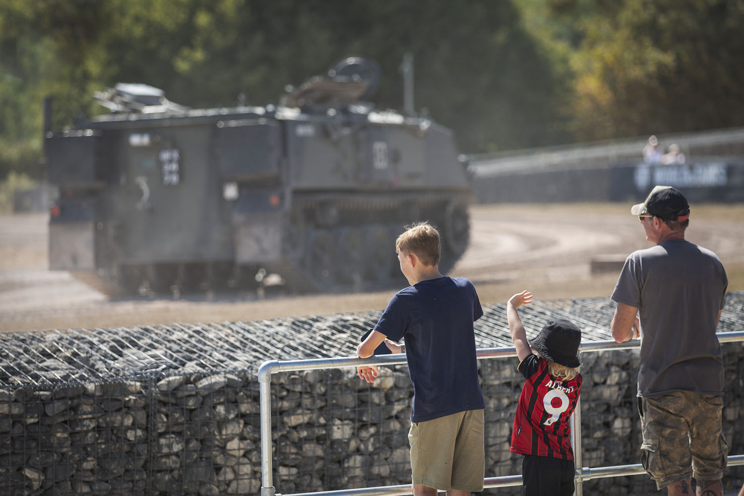 Visitors watching the Tanks in Action display a family of 3 watcing a tank drive around the arena