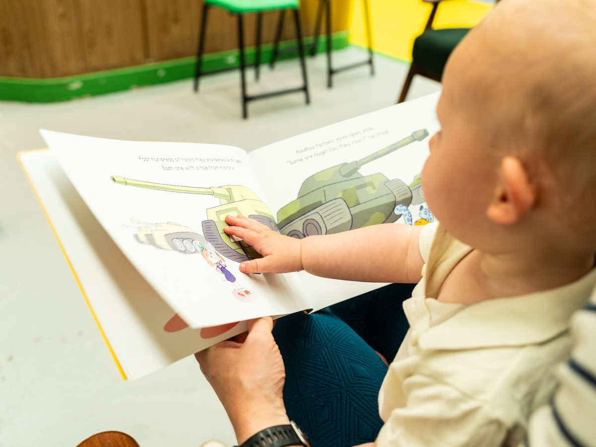 A rhyming book for young children to prepare for their visit or relive a day of great memories. Young child reading a colourful childrens book