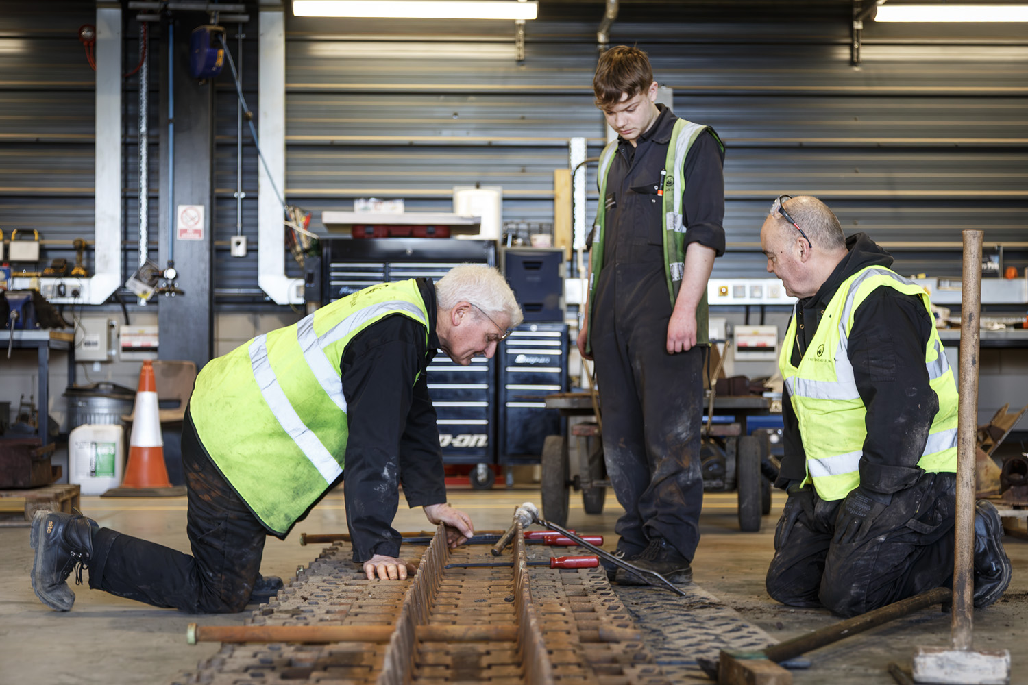 Apprentice Vehicle Technician James (middle) working with other members of the Workshop Team.