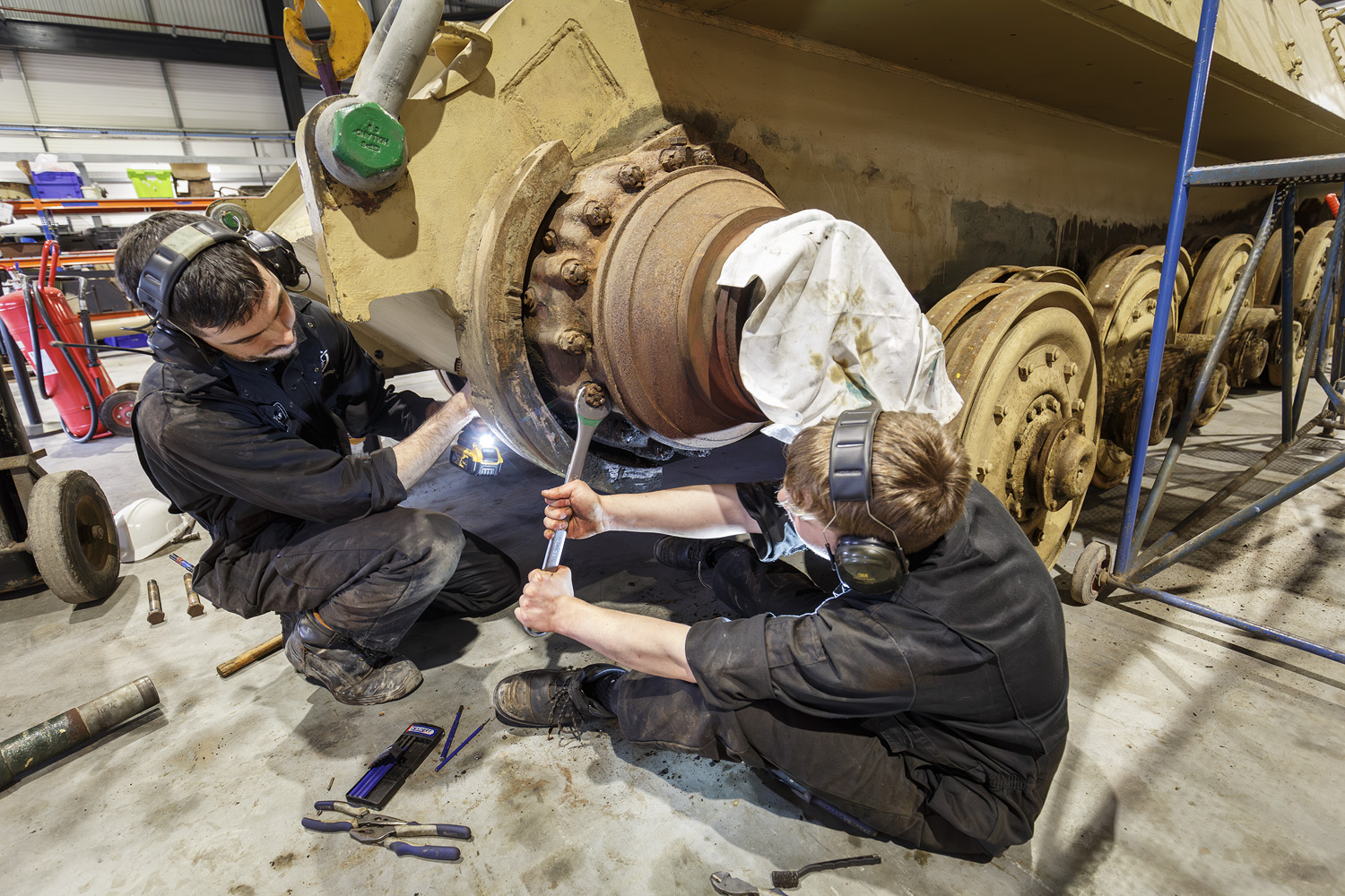Previous Apprentice Aaron (behind) and current Vehicle Technician Apprentice James (in front) removing one of the final drives on King Tiger V2.